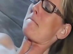 German blonde with glasses is wearing stockings and garter belt while getting fucked on the sofa