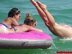 Topless ladies are enjoying on the beach while guys are staring at their bouncy tits